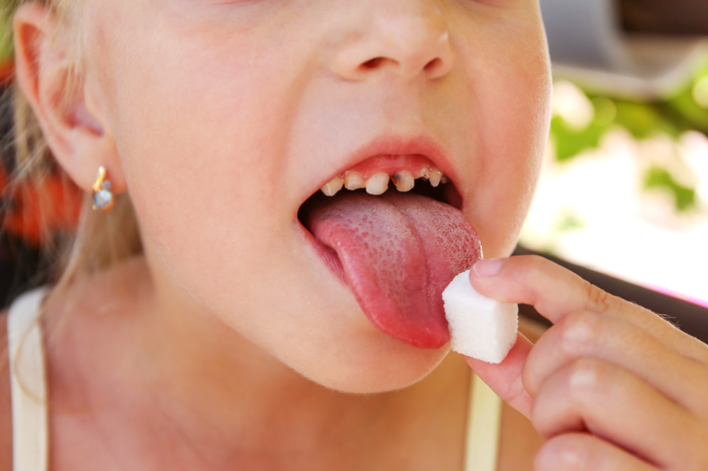 dentes cariados criança comendo açúcar 